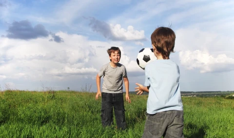 children_playing_in_grass_field